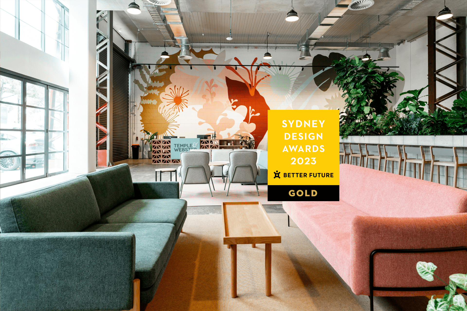 Stylish office break out space with modern furniture, warm lighting, and an open layout. Award for Sydney Design displayed in the foreground.
