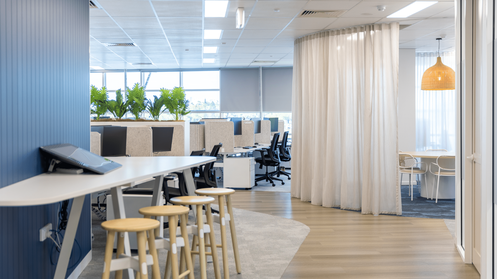 Office space with different types of work areas (general desk seating, a high bar seating area and a private room area).