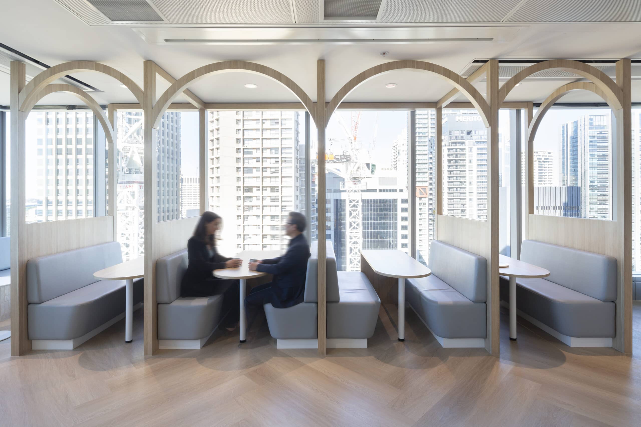 A contemporary break out space with large windows, ample seating options, and a stylish, open design for a welcoming atmosphere.