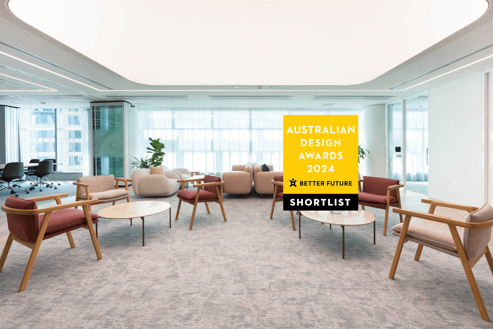 Stylish office reception with modern furniture, warm lighting, and an open layout. Award for Australian Design displayed in the foreground.