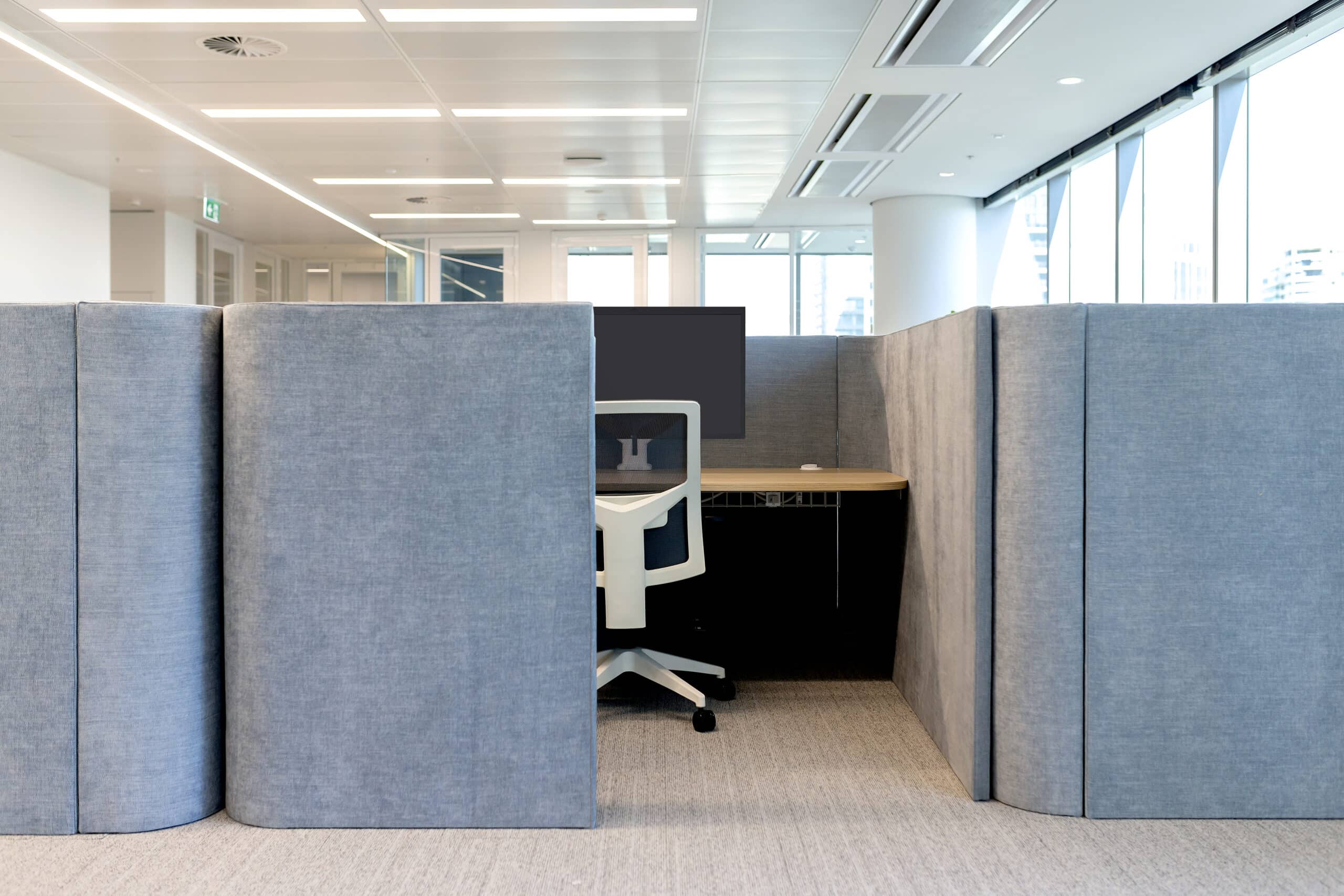 Modern office set up, stylish chairs, and sleek desks, featuring an open layout with ample natural light.