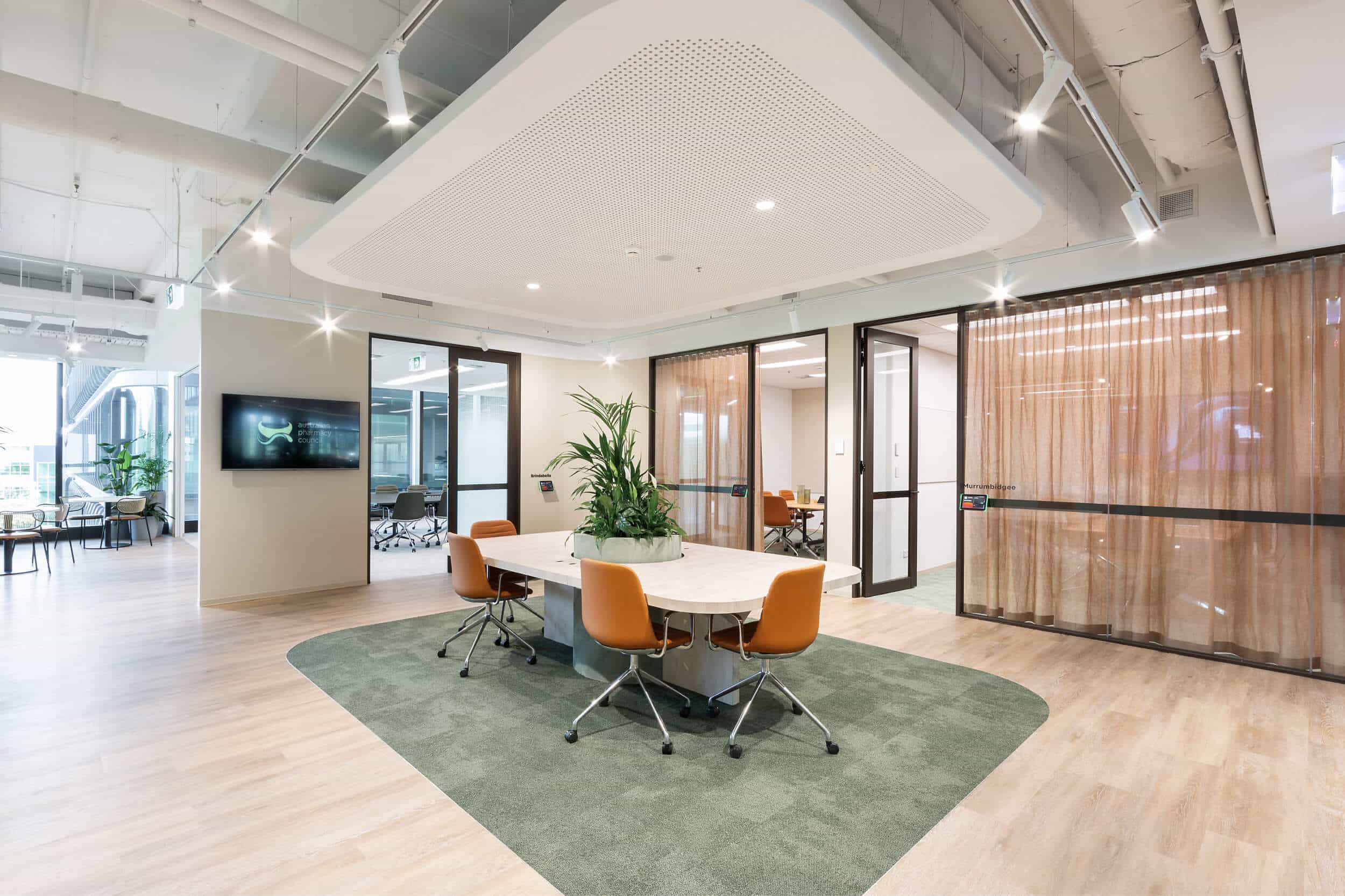 Modern meeting space area with a spacious table, designed for collaboration in a professional setting with seperate meeting rooms.