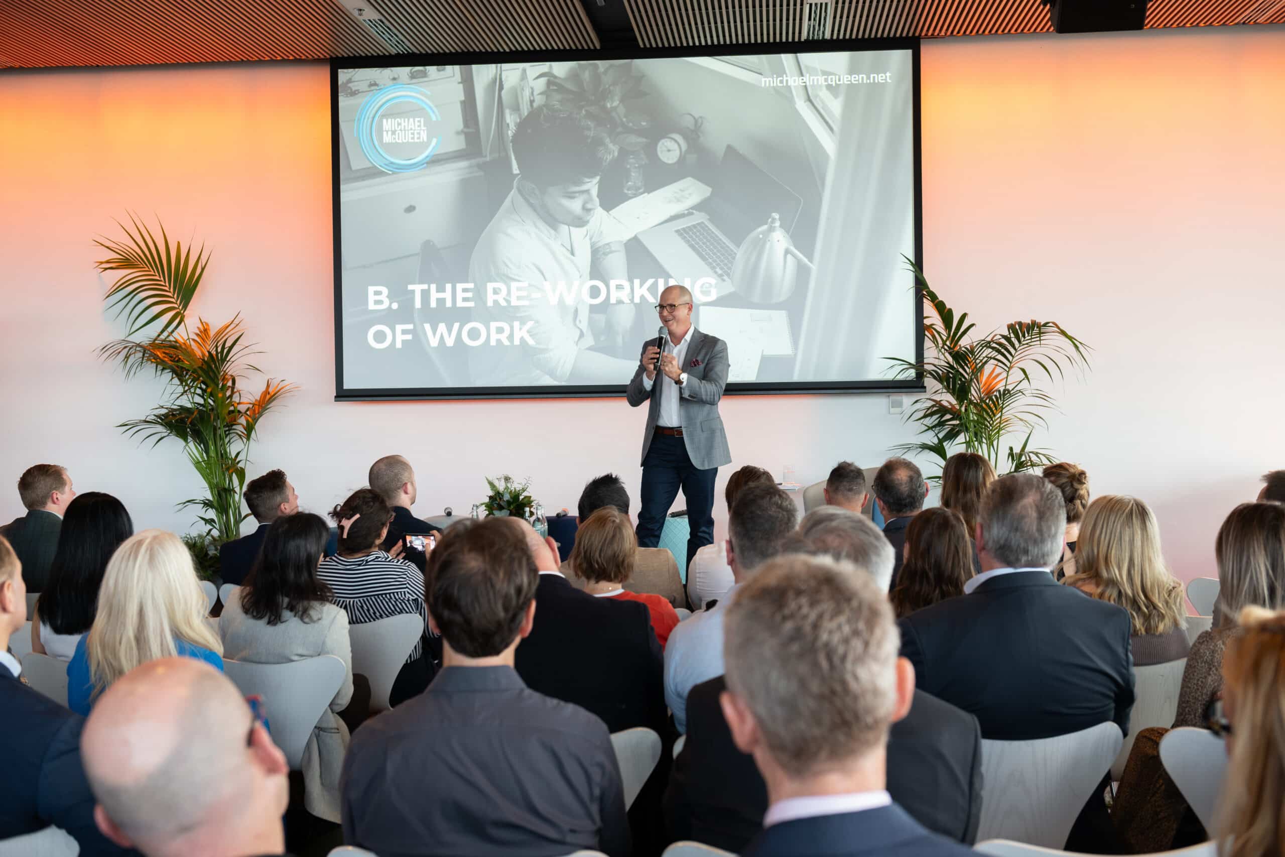 Host on stage presenting to a large audience at the Unlimited event hosted by Spaceful.