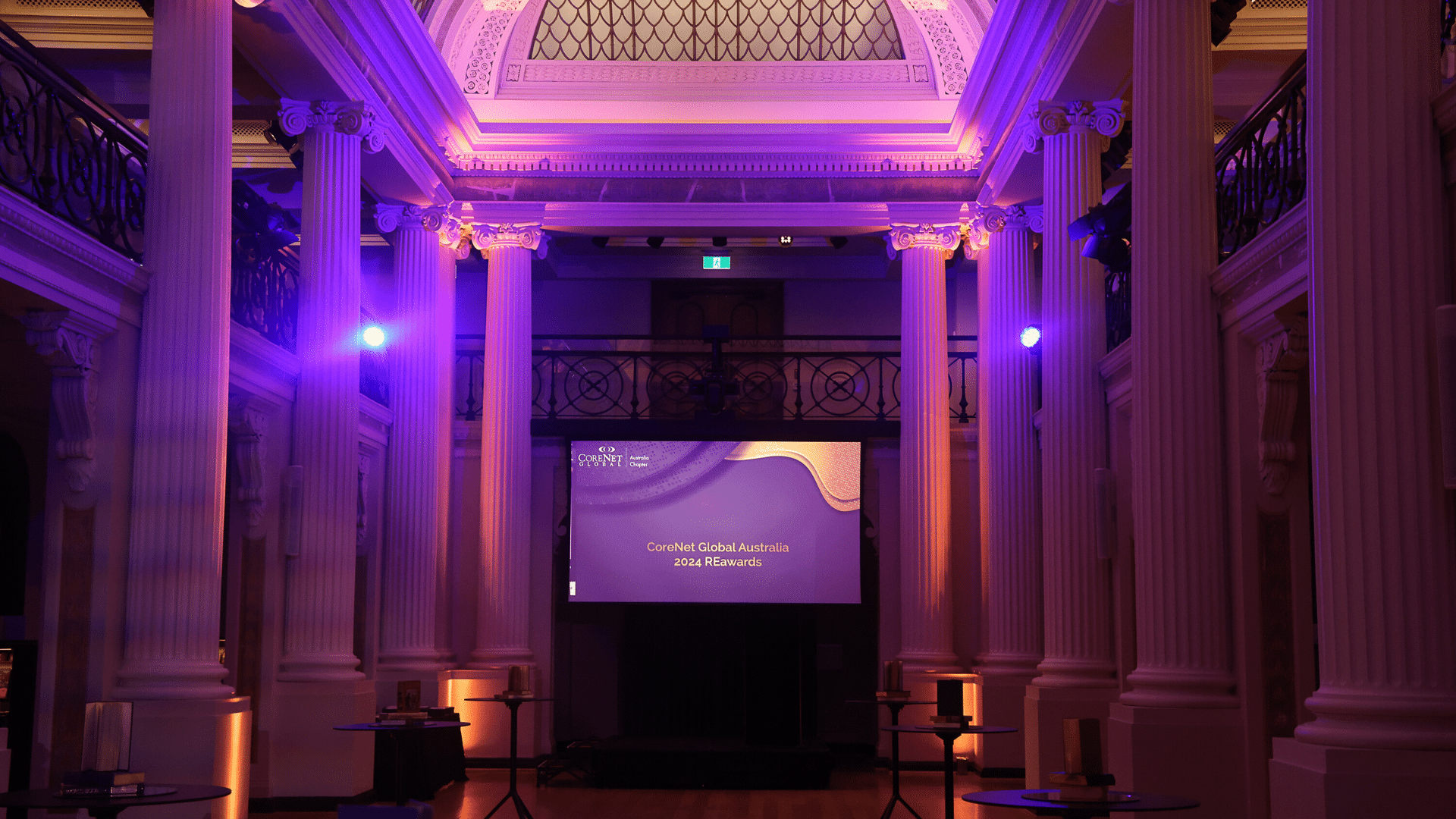 Award ceremony with purple lights and pillars.