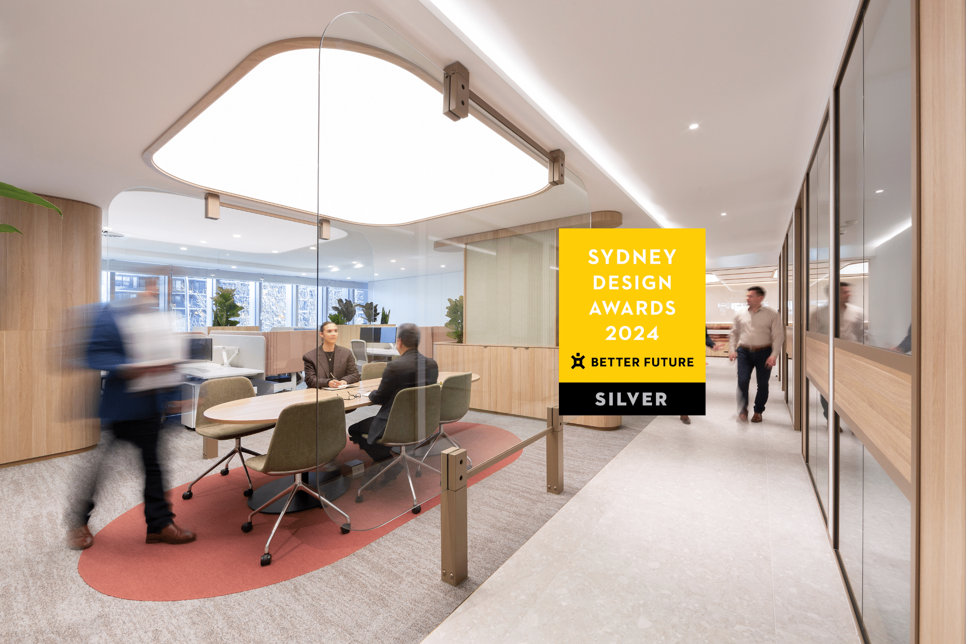 Stylish office with modern furniture, warm lighting, and an open layout. Awards for Sydney Design displayed in the foreground.