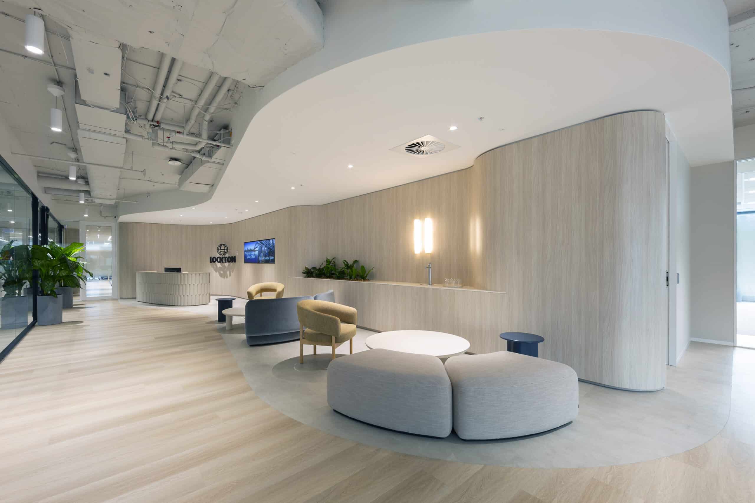 Contemporary office reception area with a sleek front desk, stylish seating, and modern design elements, creating a welcoming atmosphere.