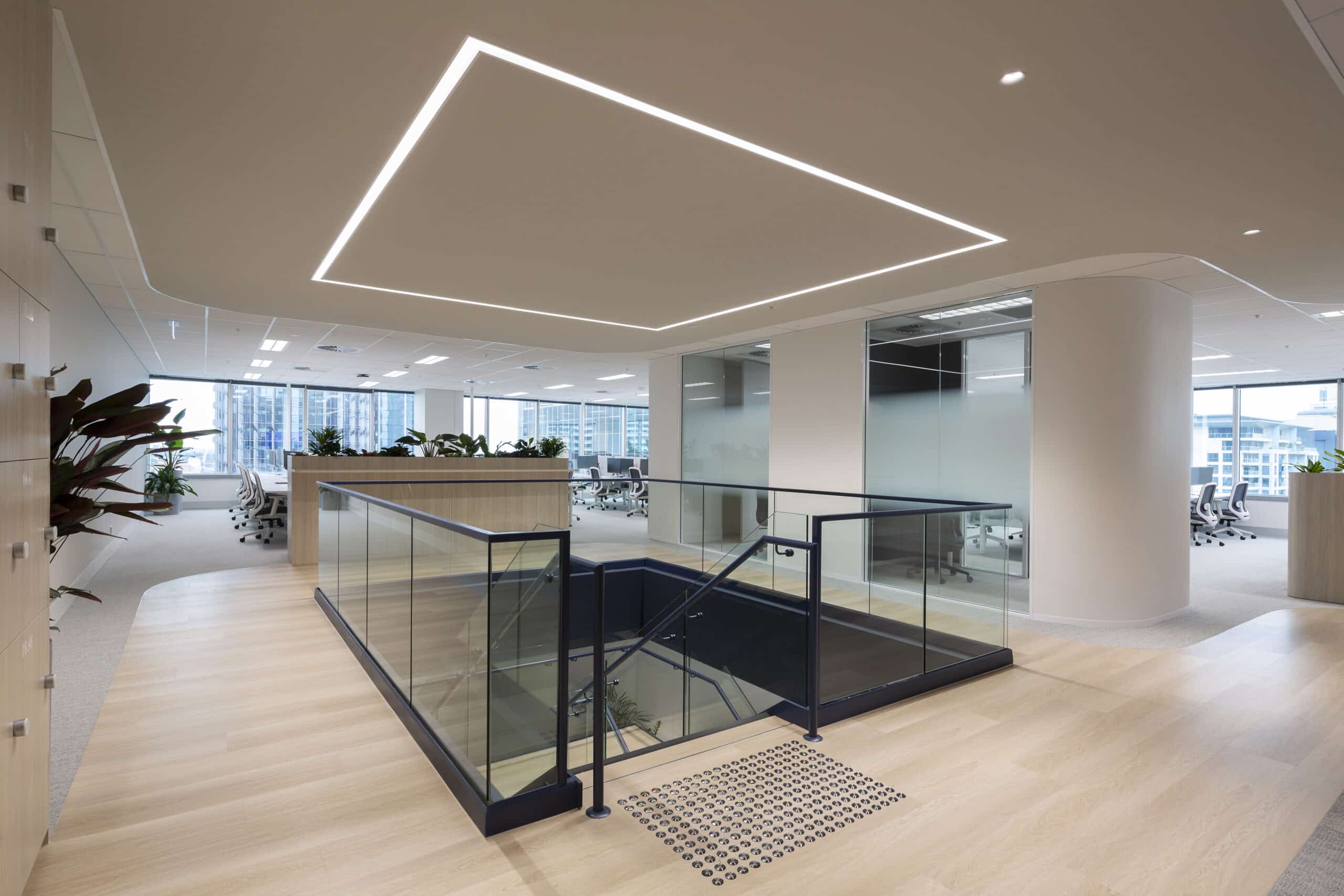 Contemporary two level office space with modern furnishings and stairs leading to the second level.