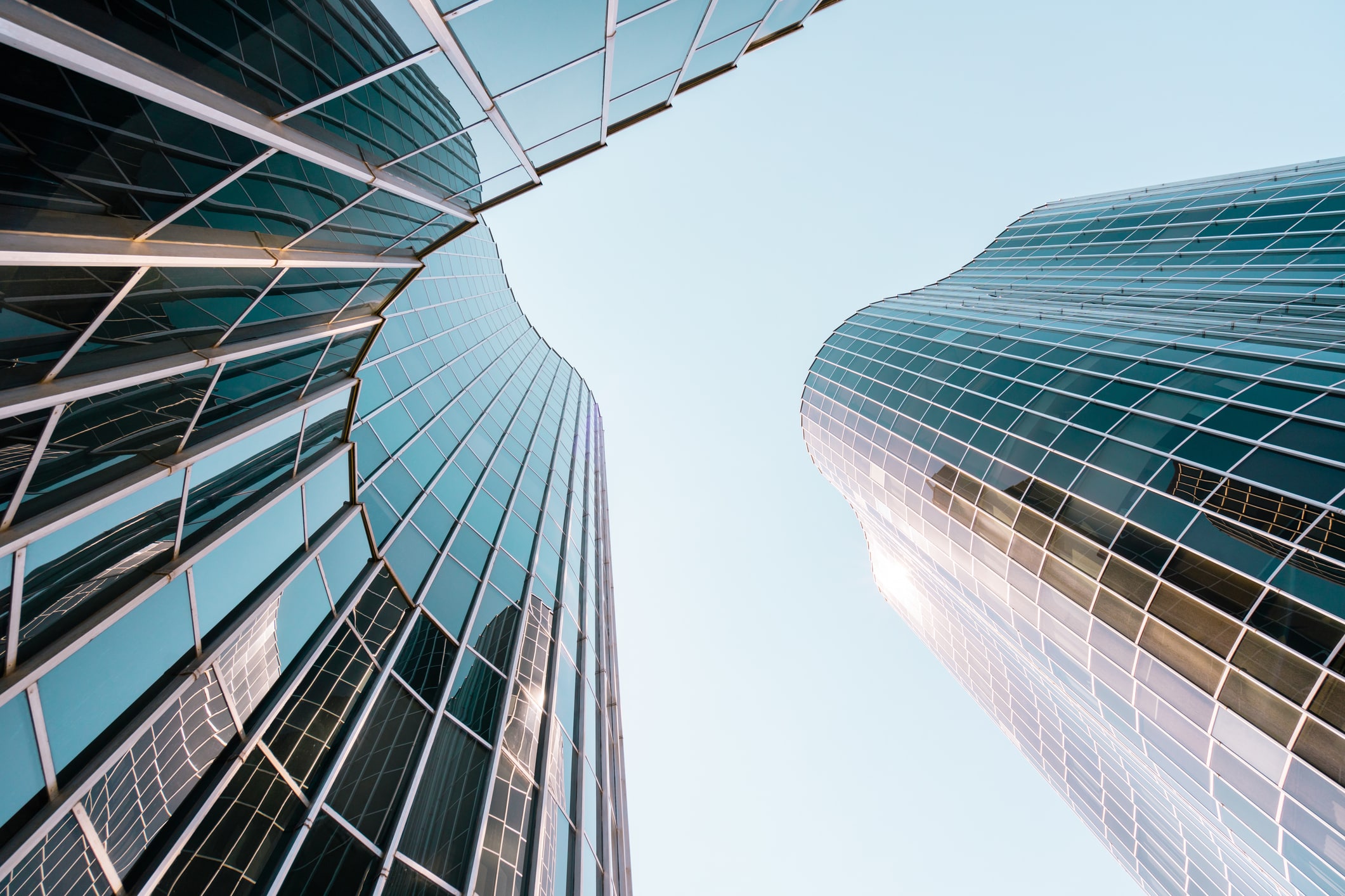 Low angle view of a curved building with glass and steel facade.