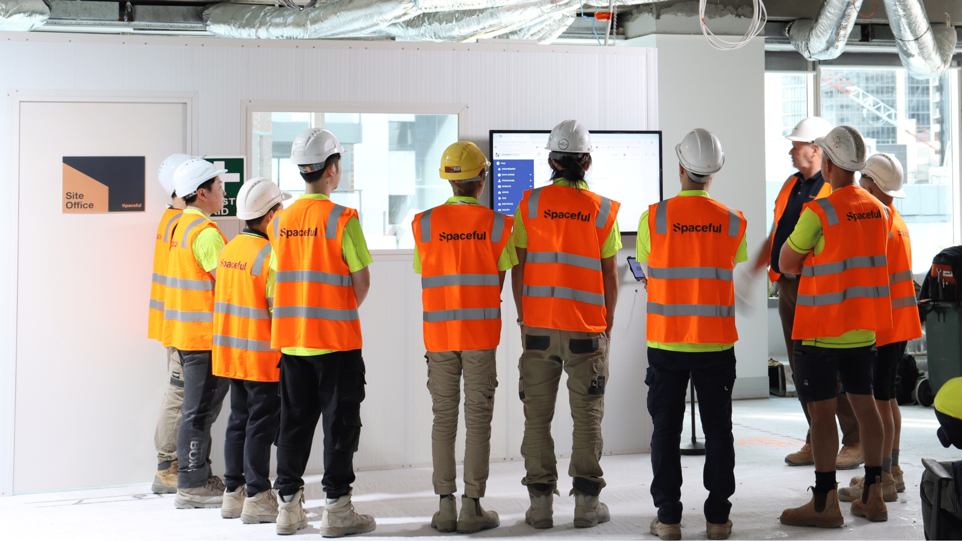 Construction workers on-site, wearing safety gear and working on a building project.