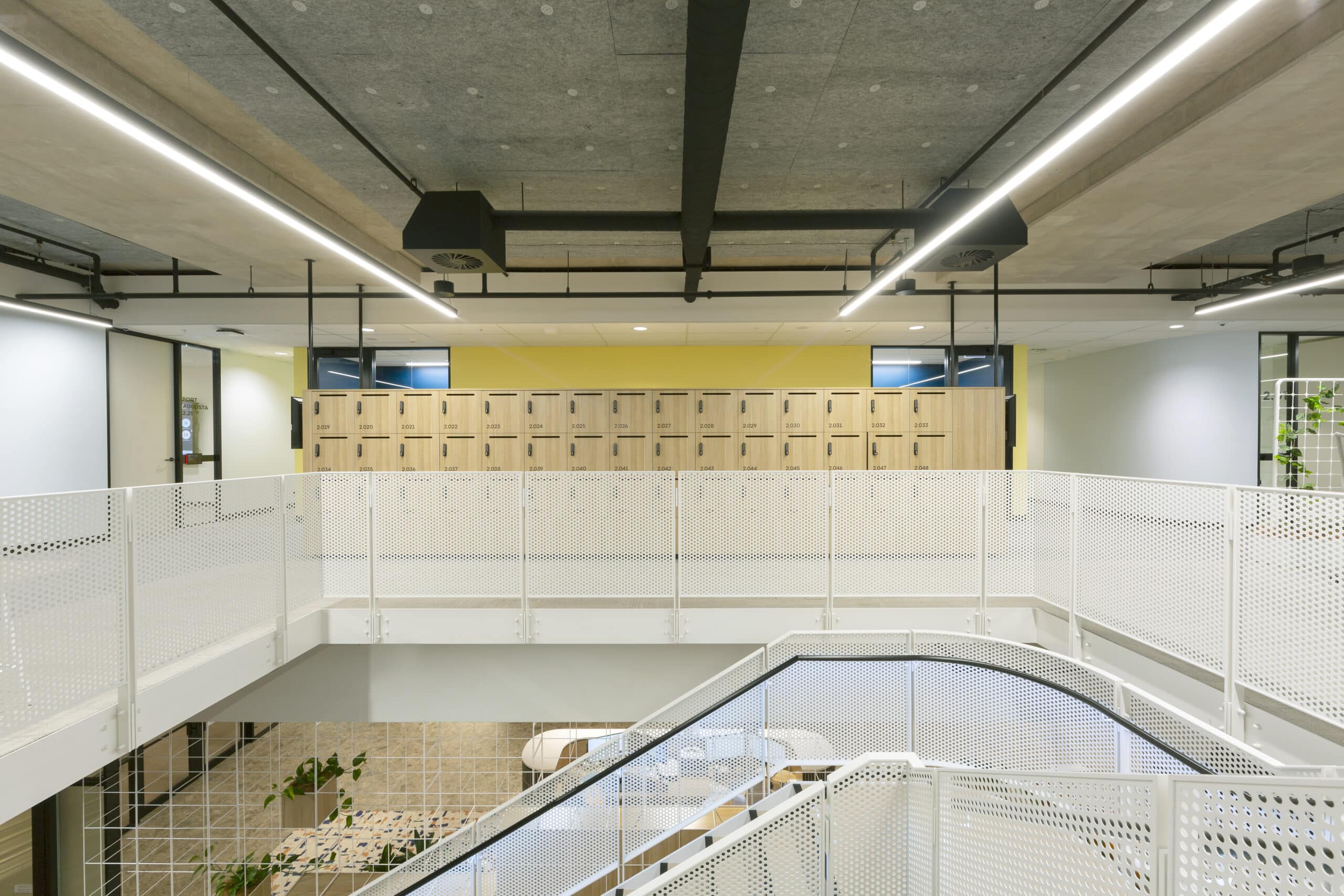 Contemporary two level office space with modern furnishings and stairs leading to the second level.