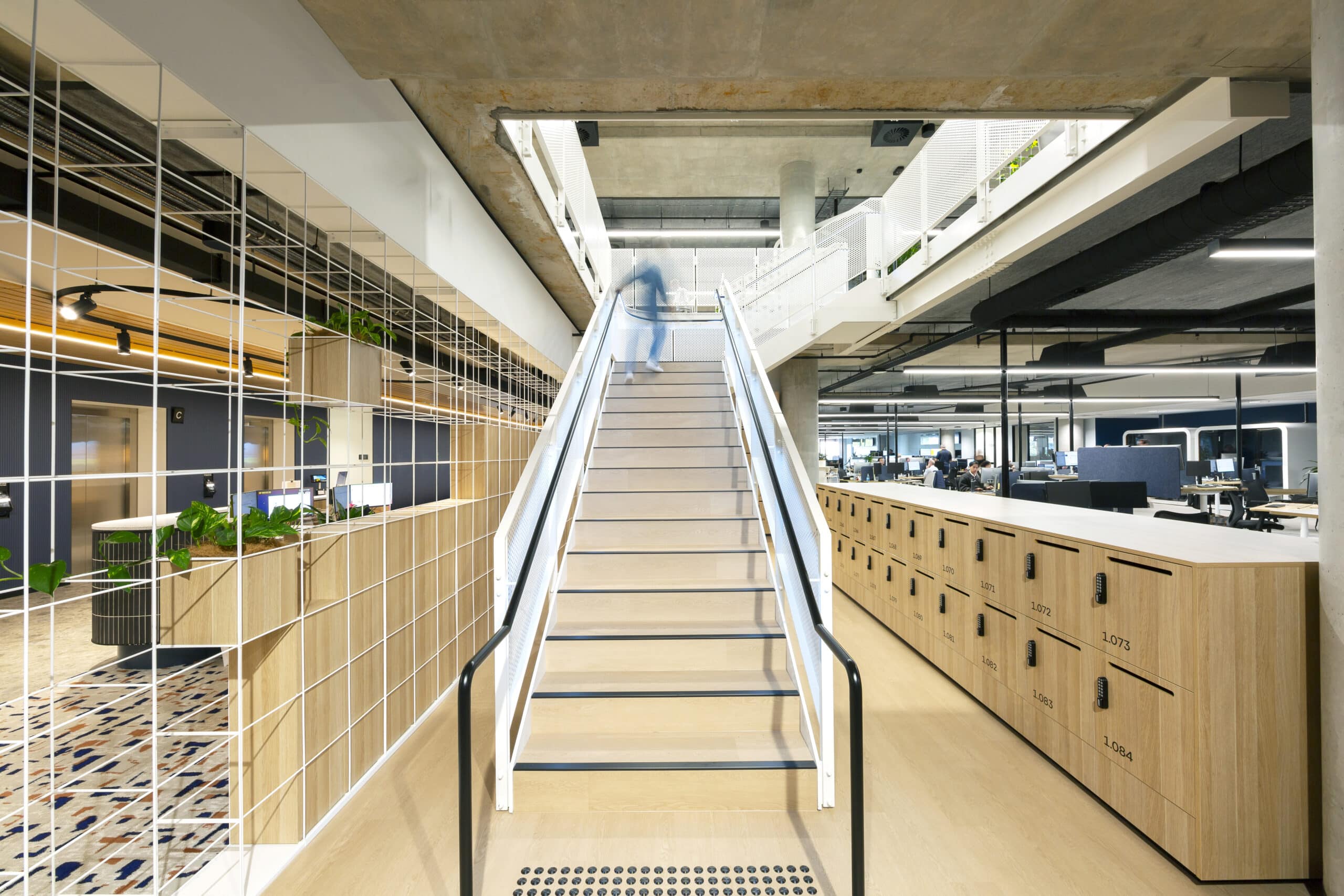 Contemporary two level office space with modern furnishings and stairs leading to the second level.