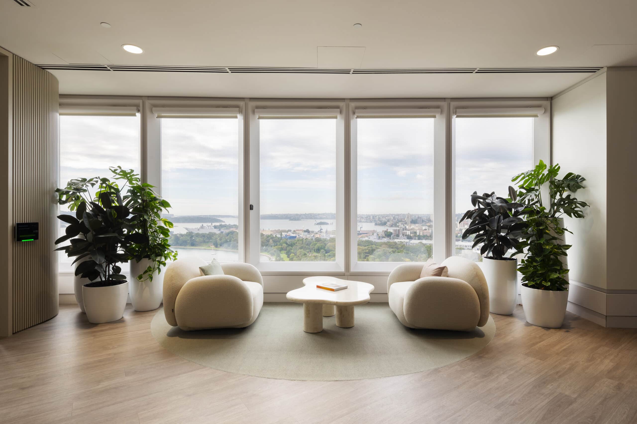 Elegant office reception featuring large windows, natural lighting, and modern furnishings, creating a professional and inviting atmosphere.